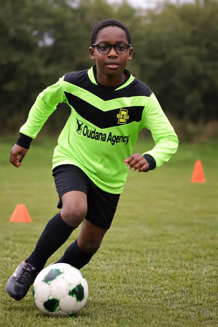 A young Box to Box player dribbling the ball